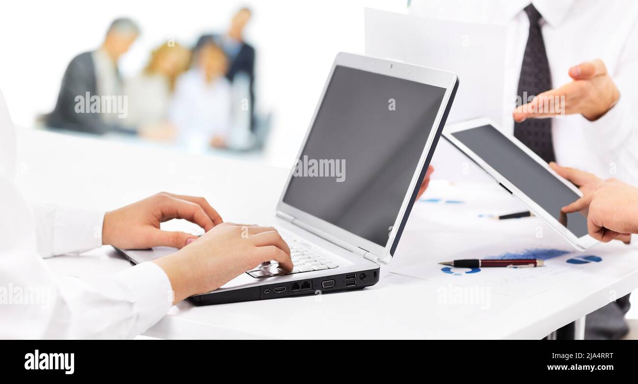 Using Computer With Partner Portrait of smart business partners using laptop at meeting Stock Photo ...