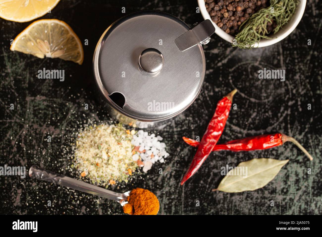 Metal container for spices with assortment of spices for cooking on a