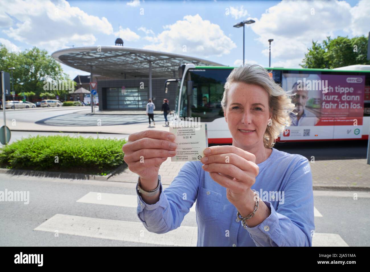 Einfuehrung des 9 EURO Tickets zur Entlastung der Buergerinnen und -Buerger fuer die hohen Spirtkosten. ine junge Frau haelt das 9-EUR-Ticket in der H Stock Photo