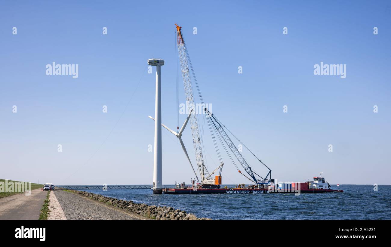 Lelystad, The Netherlands - April 22, 2022: Crane ship lifting propeller for demolition offshore wind turbine farm Stock Photo