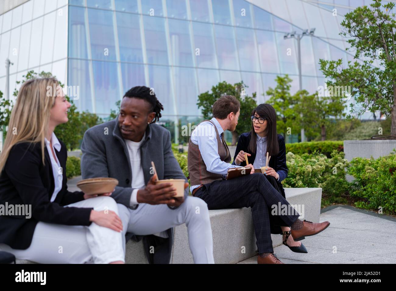 Two coworkers sharing food in financial district Stock Photo