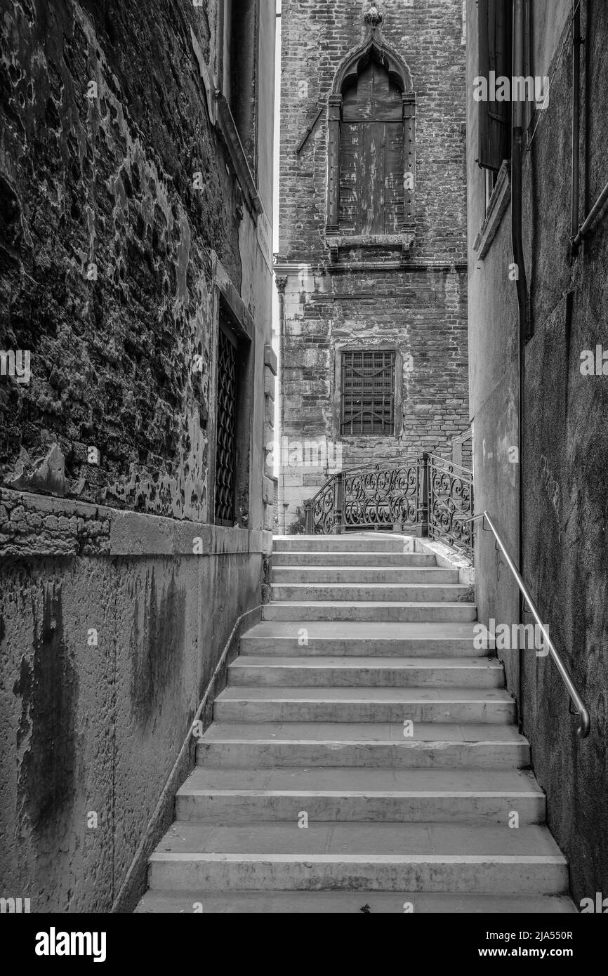 Black and white. Alley, bridge steps and deserted church, Venice, Italy Stock Photo