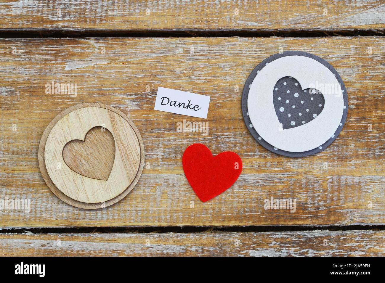 Danke (thank you in German) card with three hearts on rustic wooden surface Stock Photo