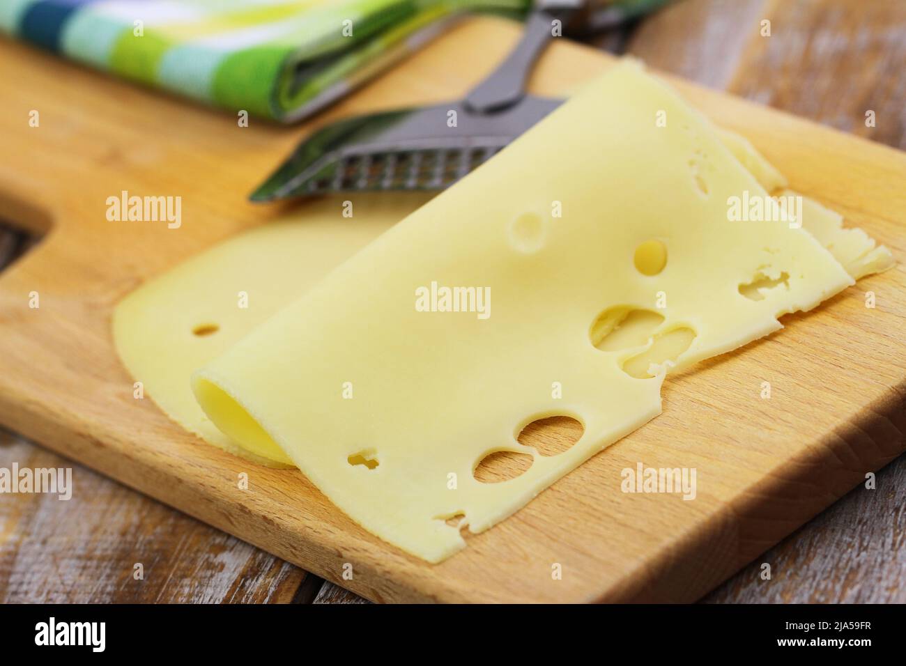 Two slices of tasty Swiss cheese on wooden board, closeup Stock Photo
