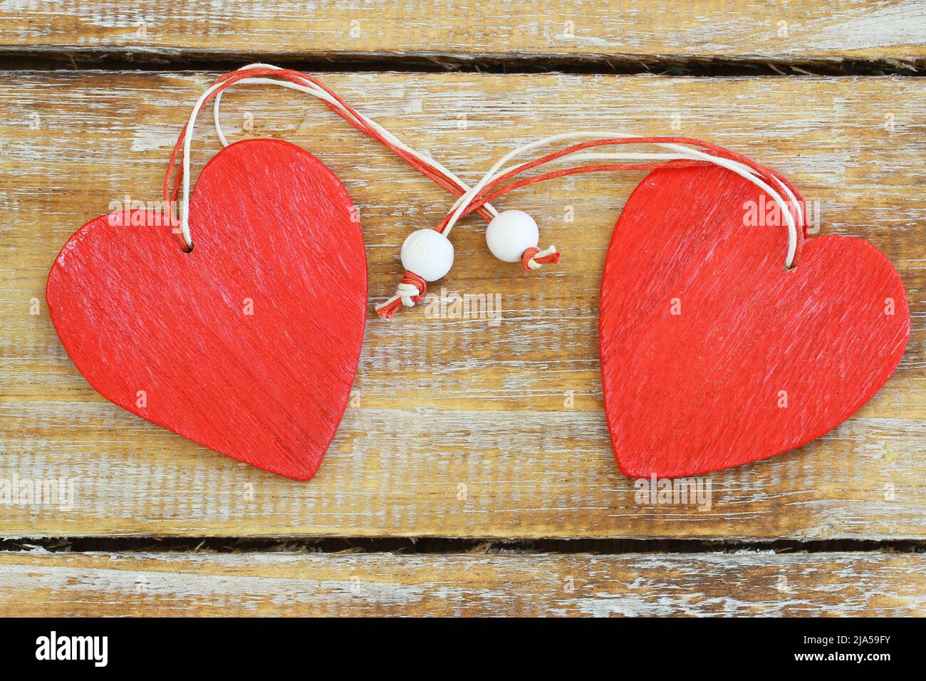 Two red wooden hearts on rustic wooden surface with copy space Stock Photo