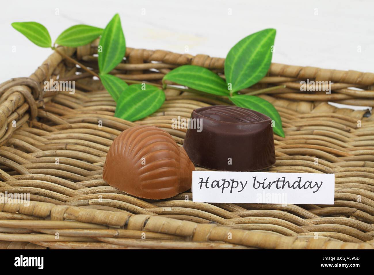 Happy birthday card with milky and dark chocolates on wicker tray Stock Photo
