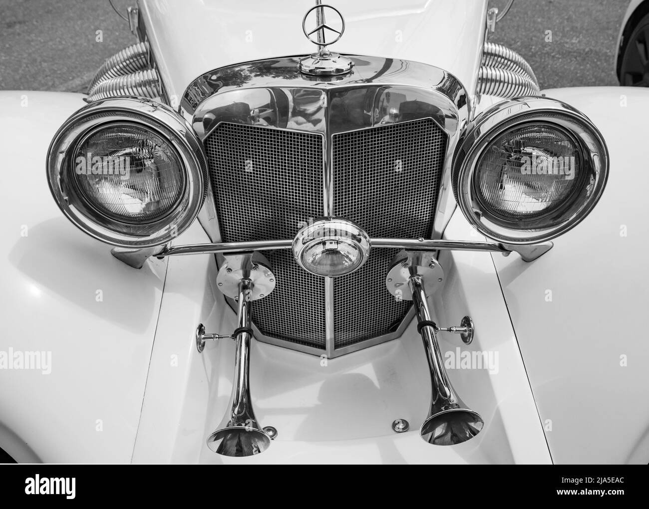 Mid-size luxury car Mercedes-Benz front, close-up details, black and white, The oldtimer show. Vintage Mercedes Benz car parked in the street. Travel Stock Photo