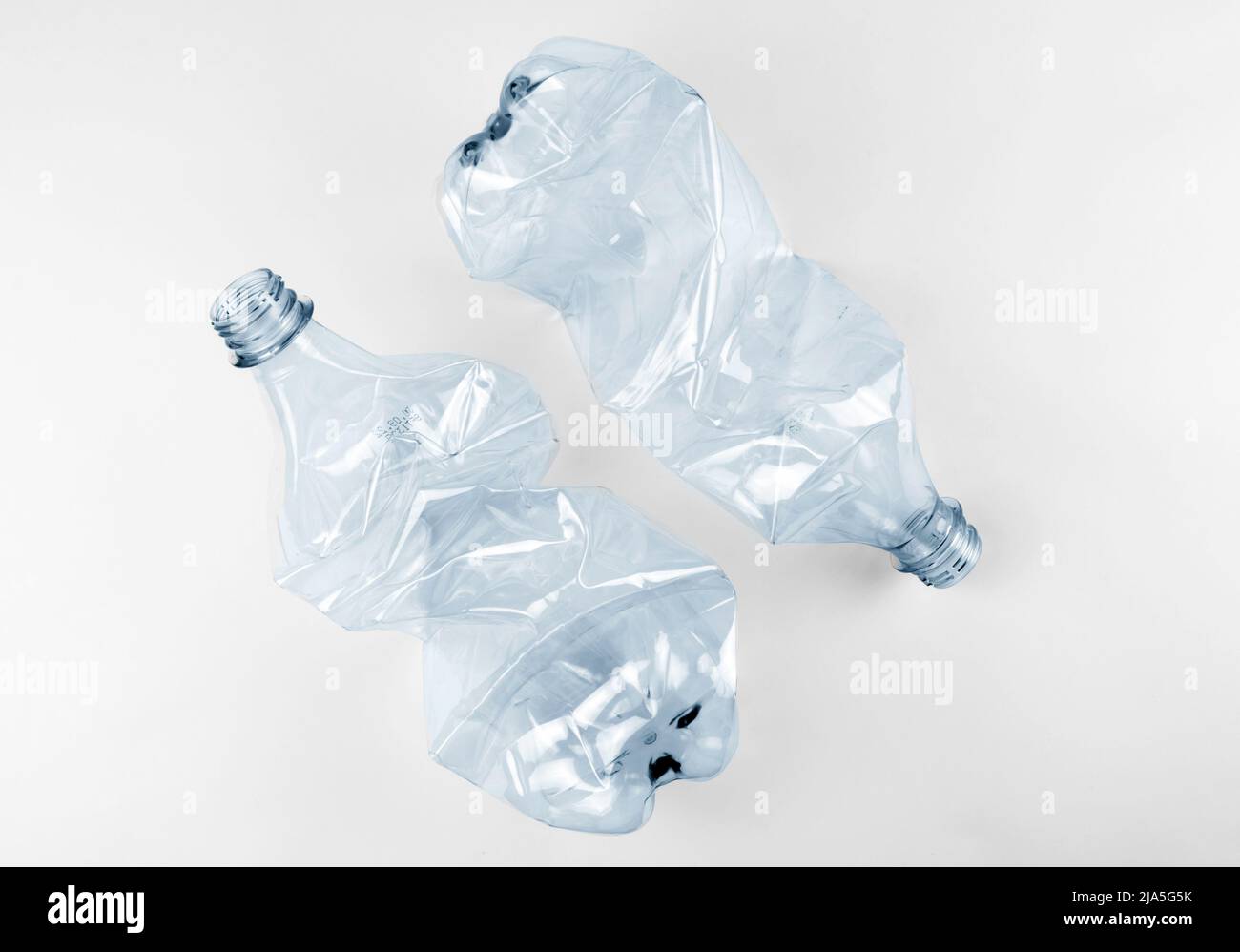 Two crumpled plastic water bottles on grey background Stock Photo