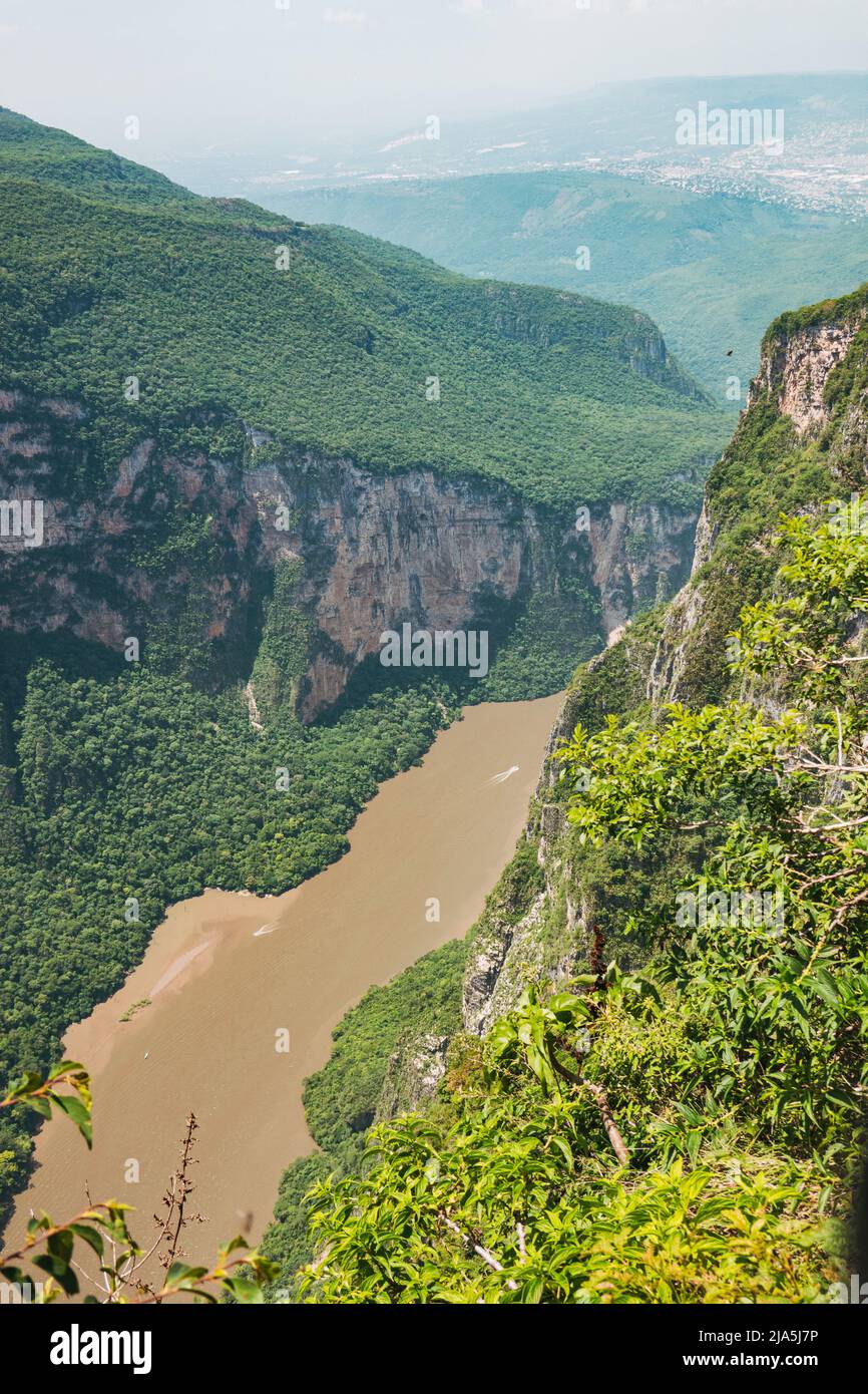 a muddy Grijalva river flows through the Sumidero Canyon, a deep natural canyon popular with tourists in Chiapas state, Mexico Stock Photo