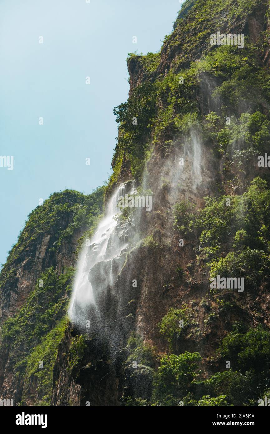a misty waterfall sprays off a cliff face in Sumidero Canyon, a deep