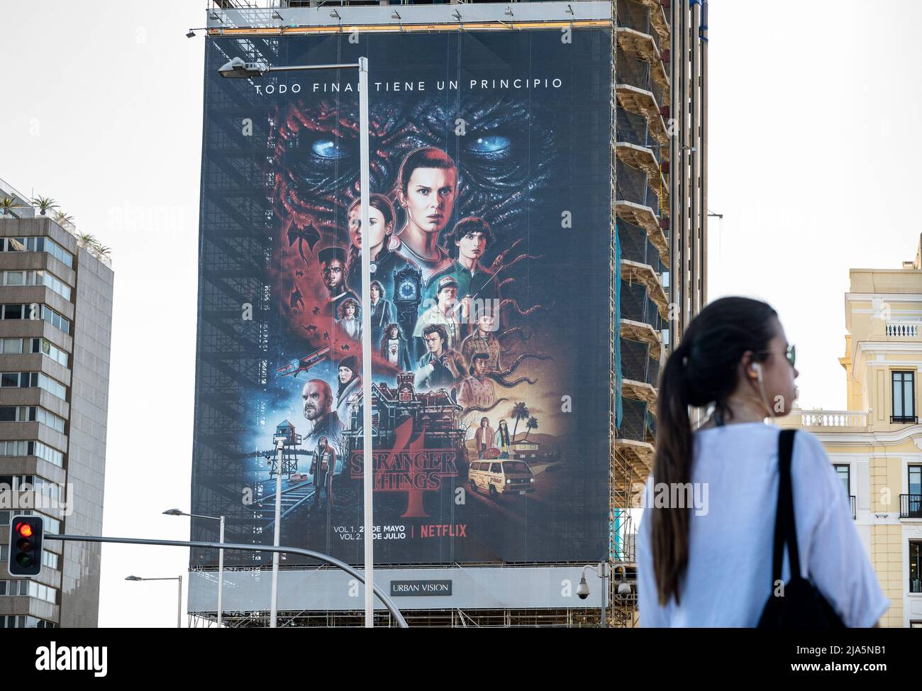 Madrid, Spain. 28th May, 2022. A woman stands opposite of a large street advertisement billboard from the American global on-demand Internet streaming media provider Netflix featuring Stranger Things Season 4 TV show in Spain. Credit: SOPA Images Limited/Alamy Live News Stock Photo