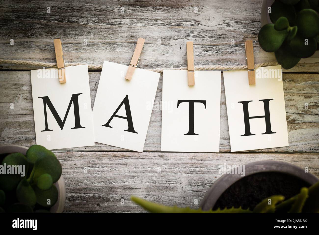 A set of printed cards spelling the word MATH on an aged wooden ...