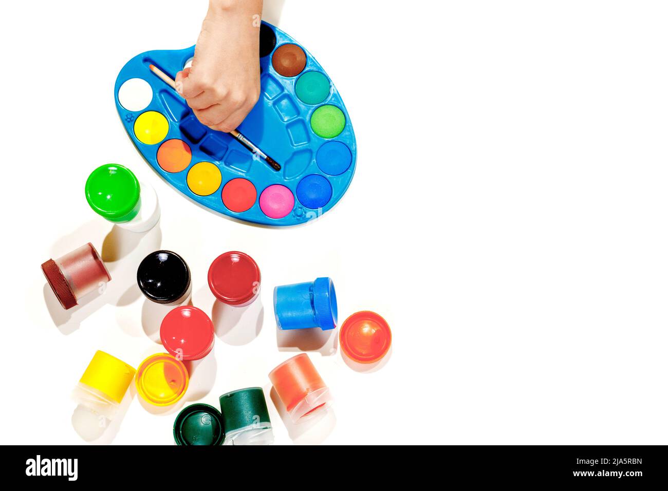 Jars with gouache multicolored paint, palette, brush. Top view.Flat lay. Stock Photo