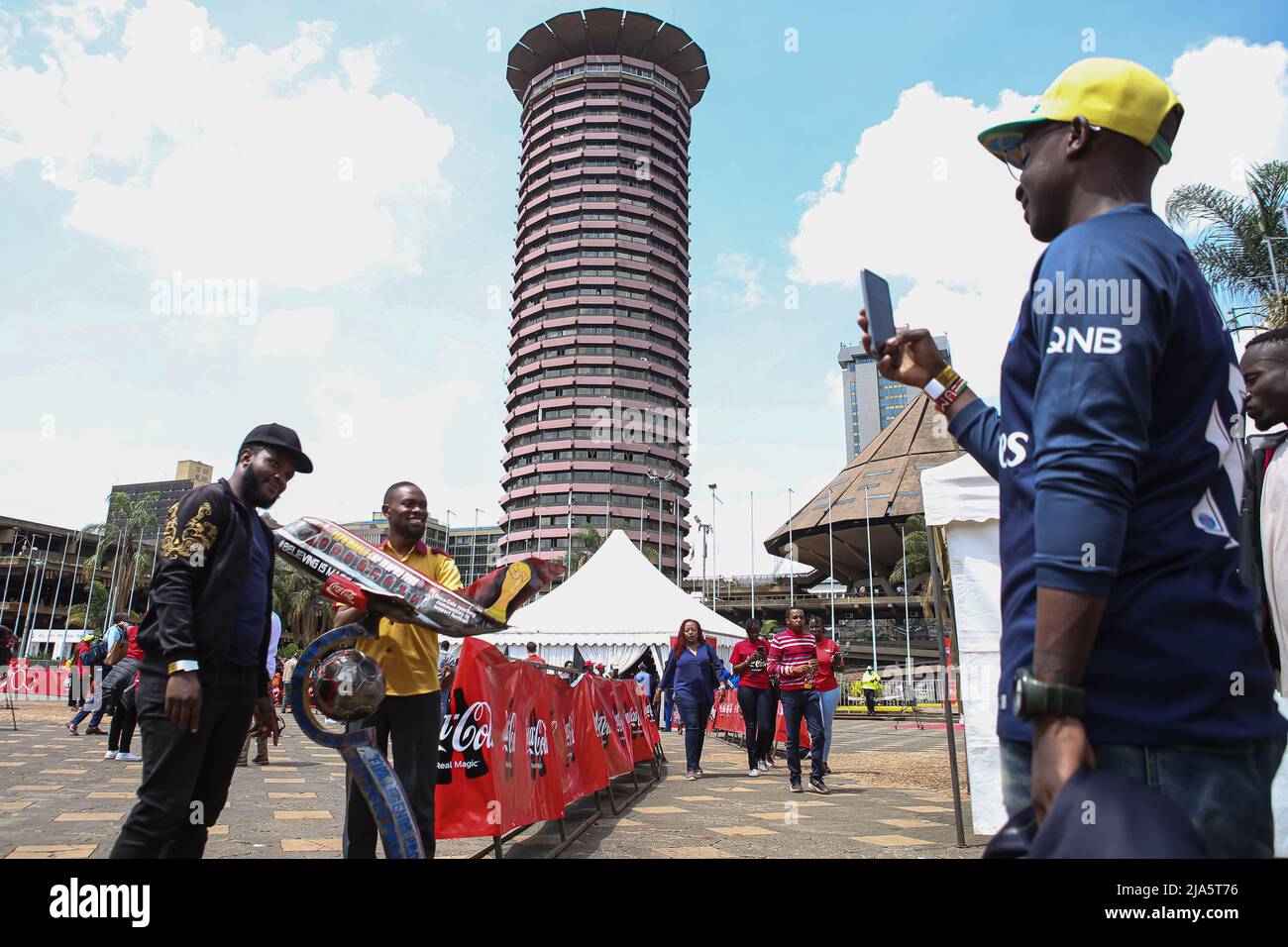 Kenyan soccer fans take photos after viewing the trophy during the FIFA