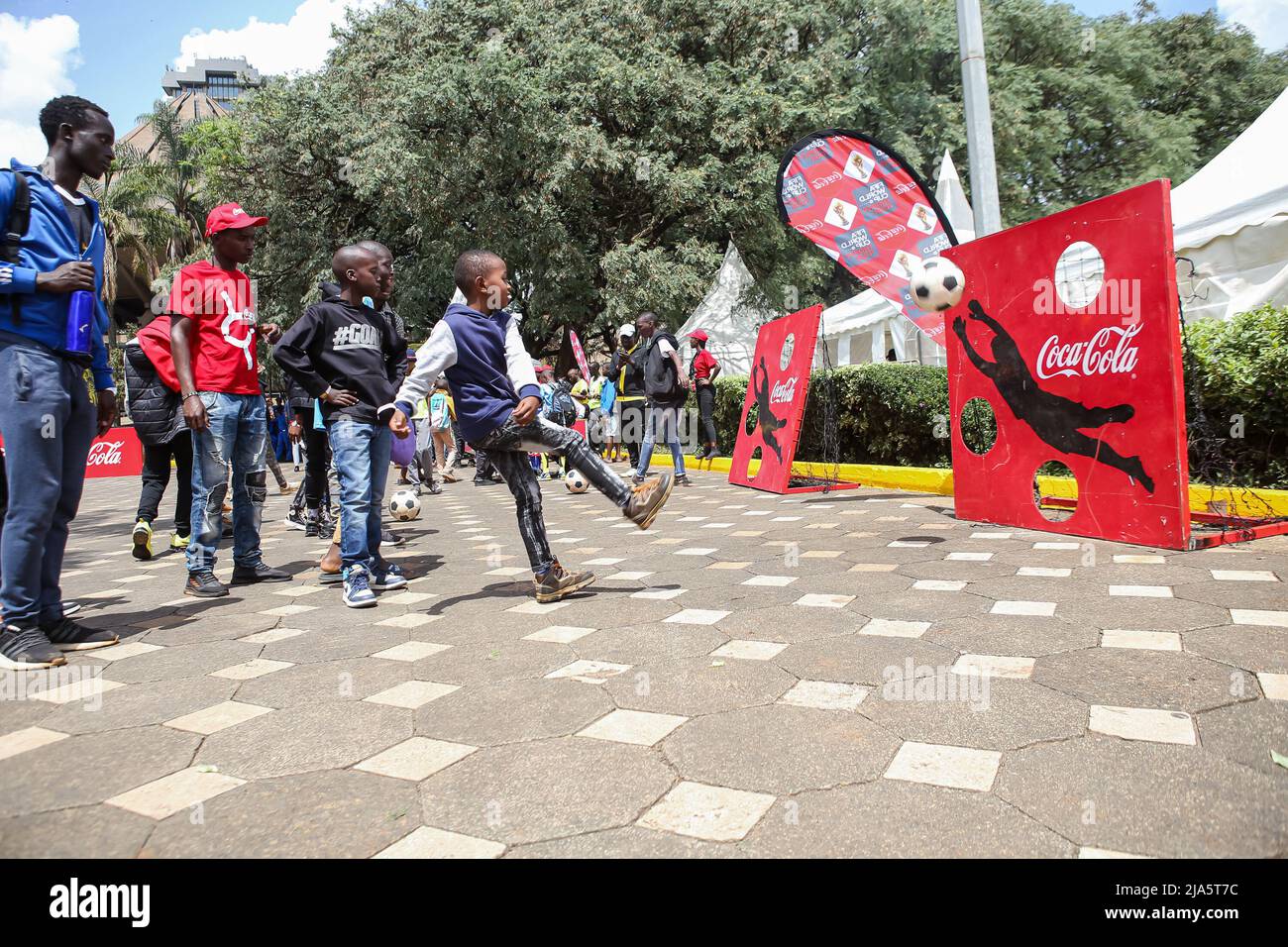 Kenyan children shoot soccer balls, one of the activities available