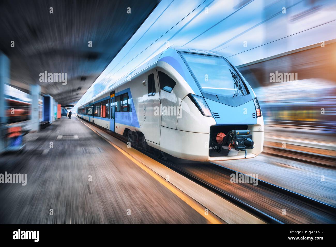 High speed train in motion on the railway station at sunset Stock Photo