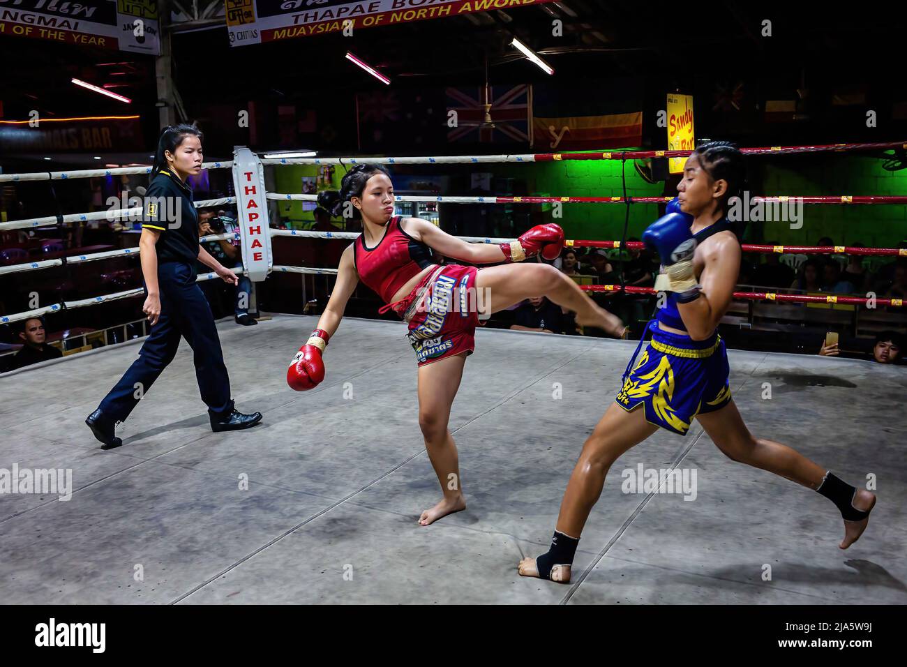 Naem Peaw (L) kicks Waewdoa during combat at Thaphae International Boxing stadium. Years ago seeing women in a ring fighting (Muay Thai) in Thailand was almost unheard of, unless it was in a ceremonial fight in the local temple during the festive season. Nowadays, things are changing and more women are joining the sport. The city of Chiang Mai is the epicentre of this change with the support of a local promoter that sees the sport as a way to promote equality, and the growing interest in the sport by foreigners flocking into the city.  In some Muay Thai gyms, women already overpass the number Stock Photo
