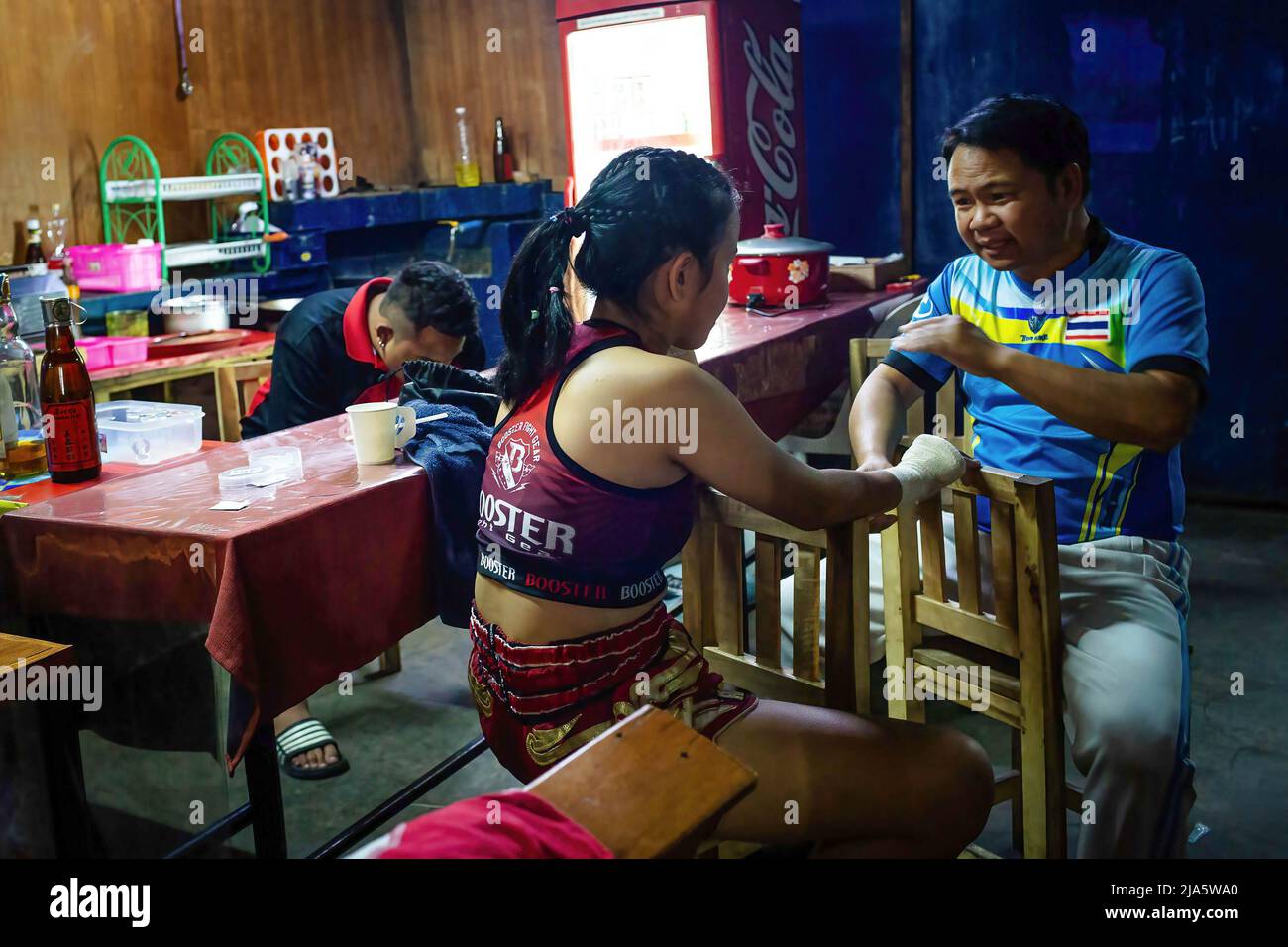 Kriswarakarn Srivichai (R) gives an indication to Naem Peaw (L) before her fight at the Thaphae International Boxing stadium. Years ago seeing women in a ring fighting (Muay Thai) in Thailand was almost unheard of, unless it was in a ceremonial fight in the local temple during the festive season. Nowadays, things are changing and more women are joining the sport. The city of Chiang Mai is the epicentre of this change with the support of a local promoter that sees the sport as a way to promote equality, and the growing interest in the sport by foreigners flocking into the city.  In some Muay Th Stock Photo