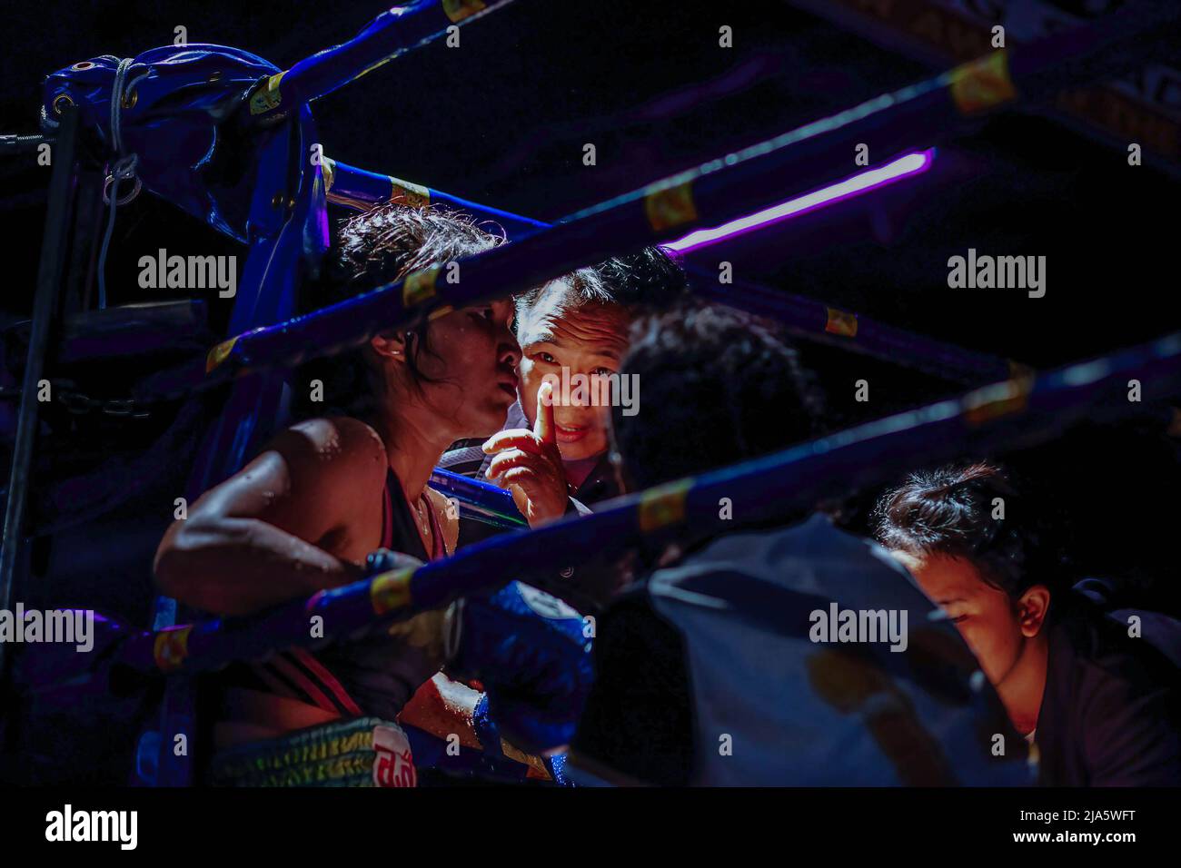 Nitida Leksanun receives indications from her coach during a fight at the Thaphae International Boxing stadium. Years ago seeing women in a ring fighting (Muay Thai) in Thailand was almost unheard of, unless it was in a ceremonial fight in the local temple during the festive season. Nowadays, things are changing and more women are joining the sport. The city of Chiang Mai is the epicentre of this change with the support of a local promoter that sees the sport as a way to promote equality, and the growing interest in the sport by foreigners flocking into the city. In some Muay Thai gyms, women Stock Photo
