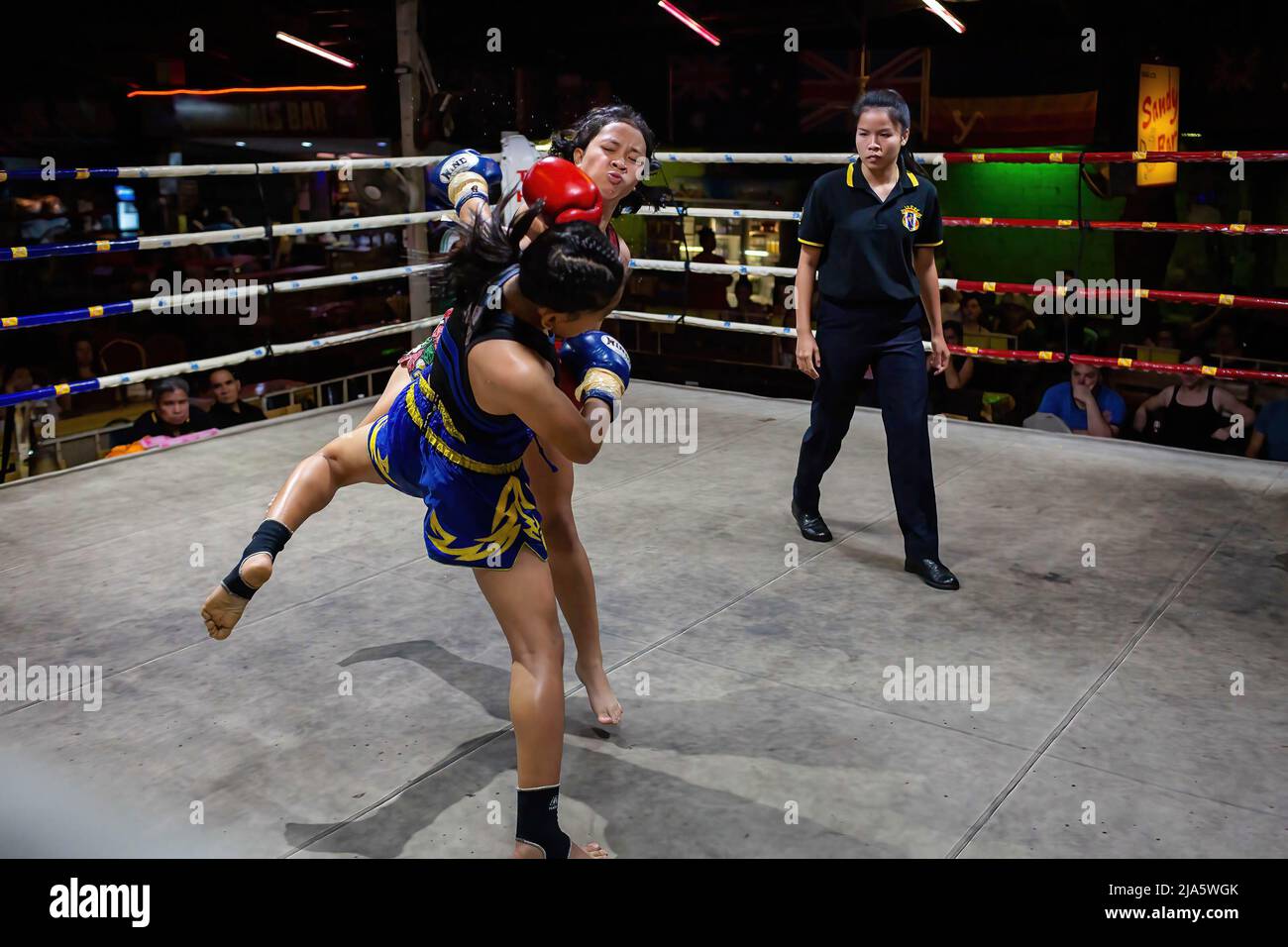 Naem Peaw punches Waewdoa during combat at Thaphae International Boxing stadium. Years ago seeing women in a ring fighting (Muay Thai) in Thailand was almost unheard of, unless it was in a ceremonial fight in the local temple during the festive season. Nowadays, things are changing and more women are joining the sport. The city of Chiang Mai is the epicentre of this change with the support of a local promoter that sees the sport as a way to promote equality, and the growing interest in the sport by foreigners flocking into the city. In some Muay Thai gyms, women already overpass the number of Stock Photo