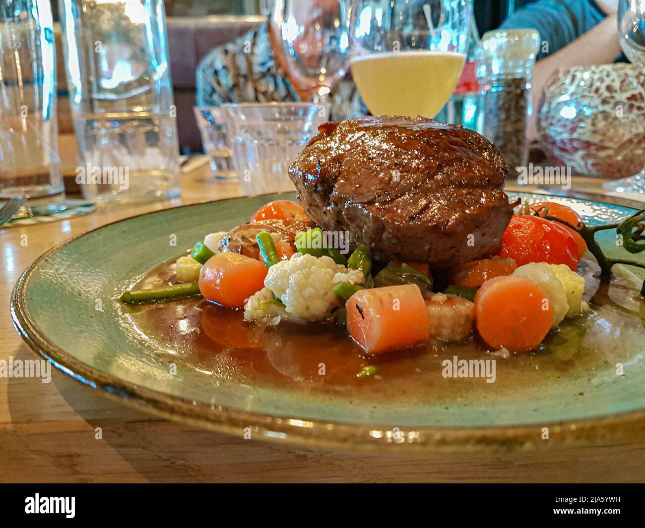Black angus steak with vegetable garnish on a luxury board served in a restaurant Stock Photo