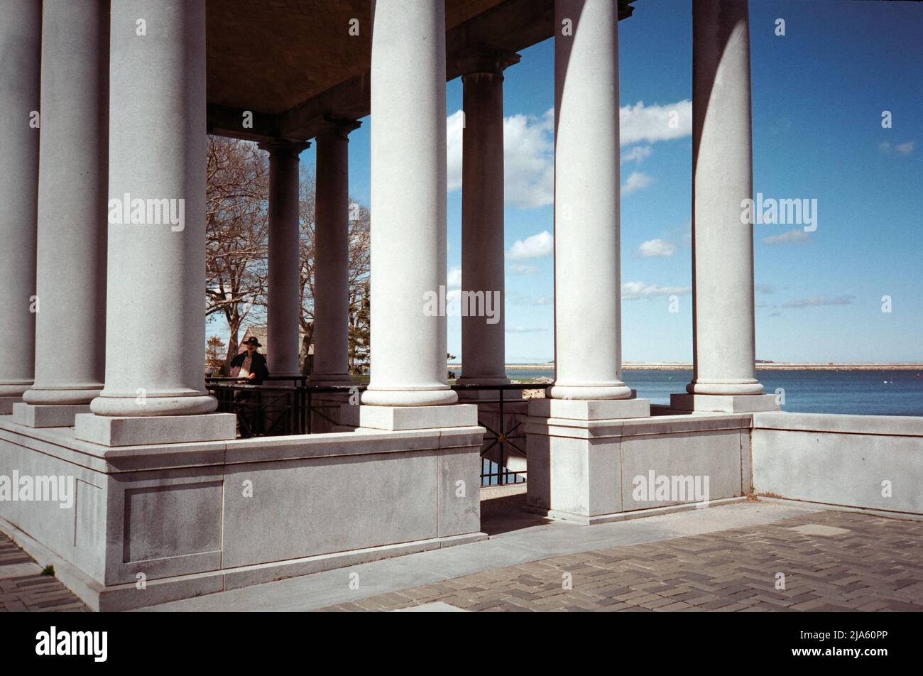 A tour guide stands in the shade of the Plymouth Rock monument as golden hour sets in at Plymouth Harbor. Plymouth Massachusetts. The image was captur Stock Photo