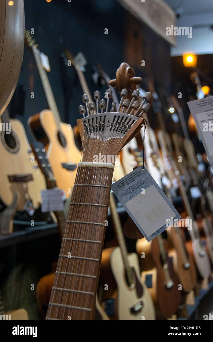 Musical instrument shop with acoustic guitars and Portuguese guitars. String instruments. Stock Photo