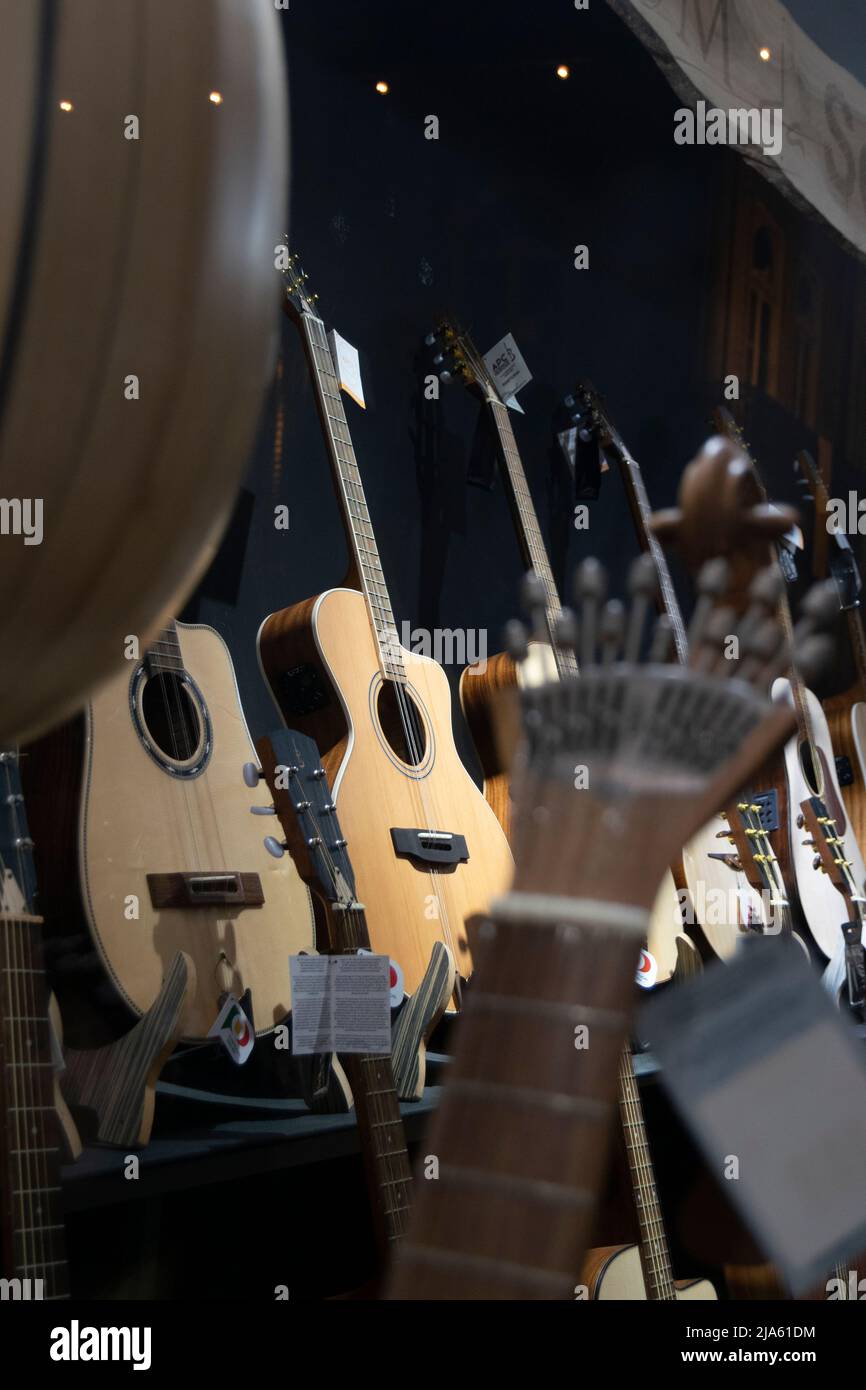 Musical instrument shop with acoustic guitars and Portuguese guitars. String instruments. Stock Photo