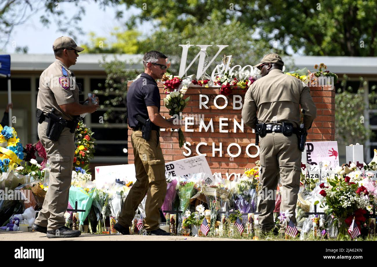 Uvalde, USA. 27th May, 2022. Police officers lay flowers at Robb Elementary School in the town of Uvalde, Texas, the United States, May 27, 2022. At least 19 children and two adults were killed in a shooting at Robb Elementary School in the town of Uvalde, Texas, on Tuesday. Credit: Wu Xiaoling/Xinhua/Alamy Live News Stock Photo