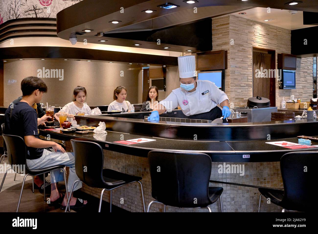 Japanese restaurant chef. Interior with female chef serving customers Thailand Southeast Asia Stock Photo
