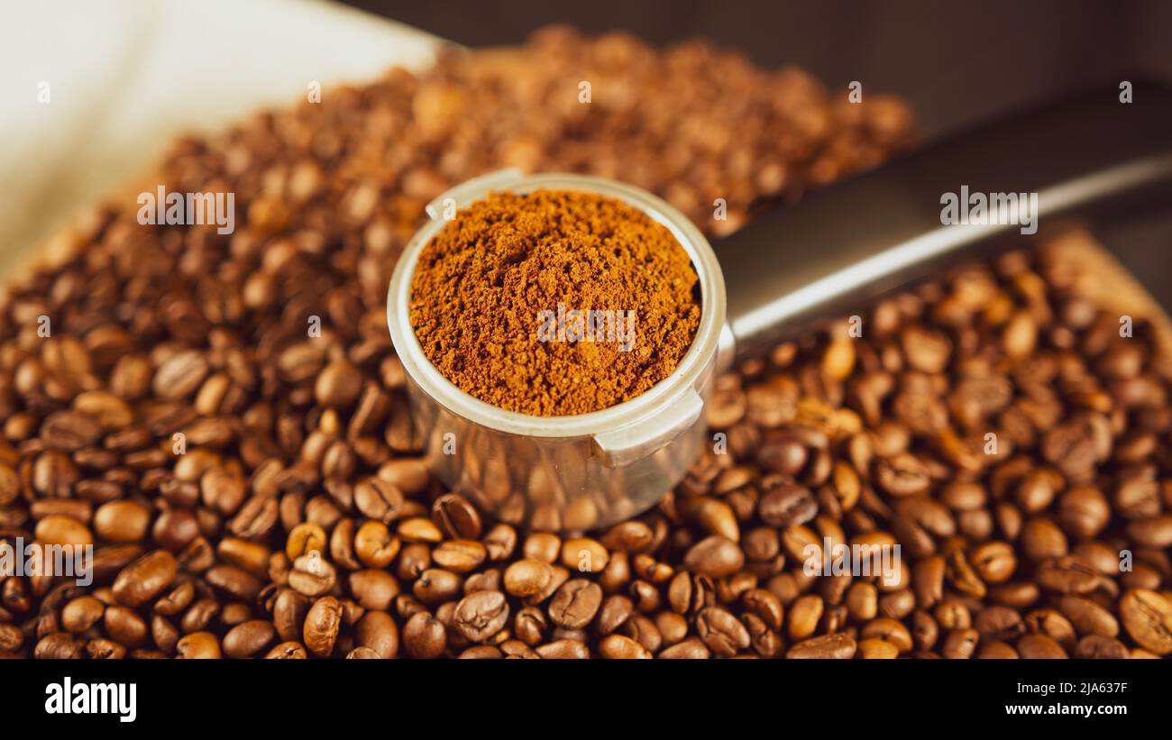 Ground coffee in portafilter on wooden board with coffee beans. Freshly ground coffee in filter