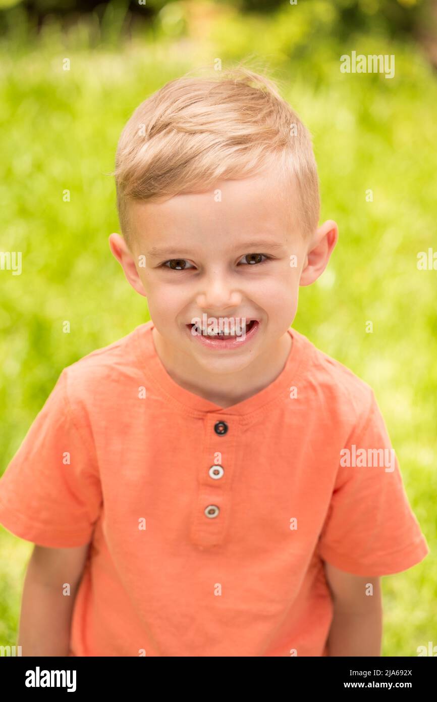 fiveyearold boy making faces. A fiveyearold blond boy makes faces while standing on the