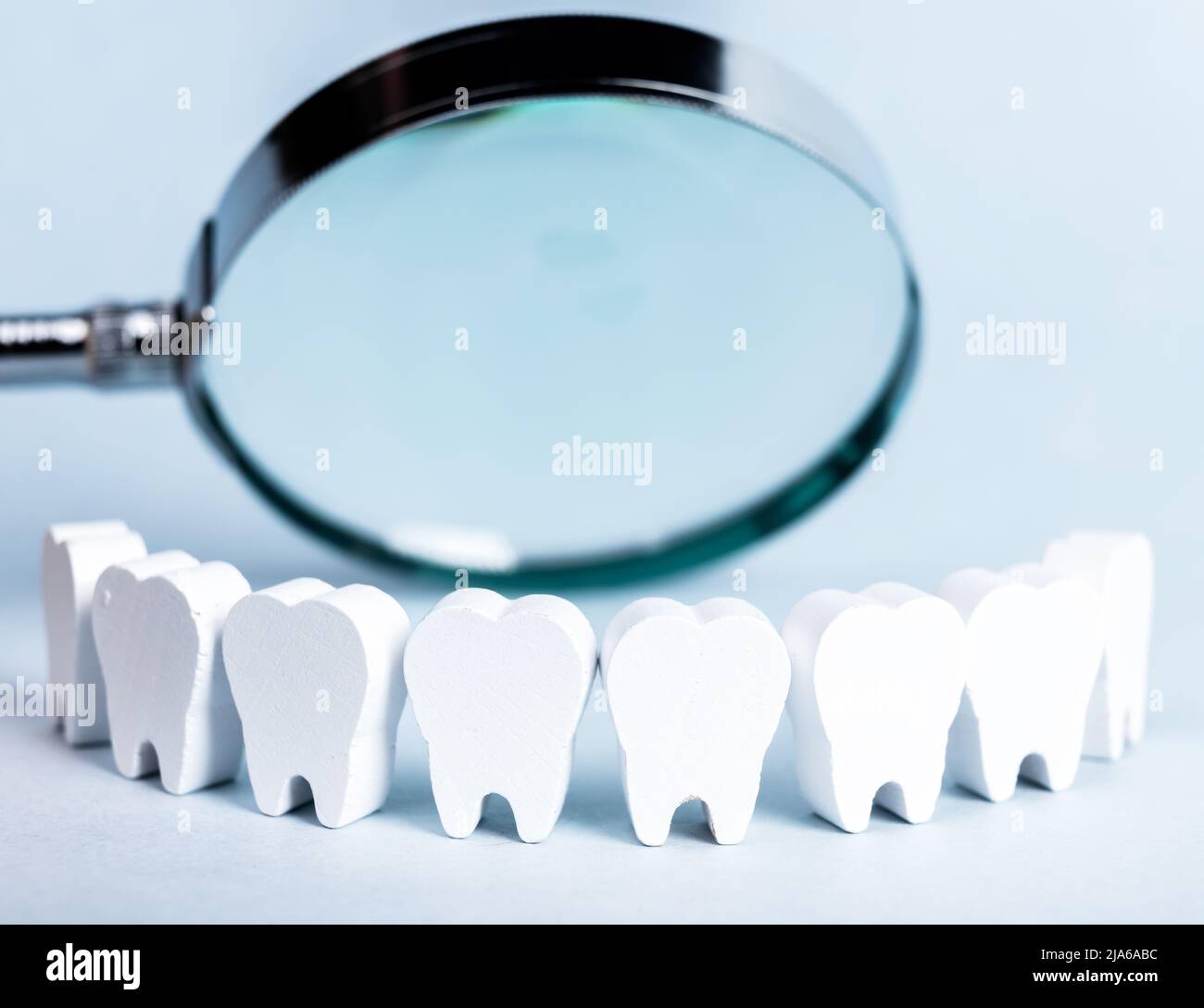 Teeth in smile form with magnifying glass. Dental checkup, tooth, gums