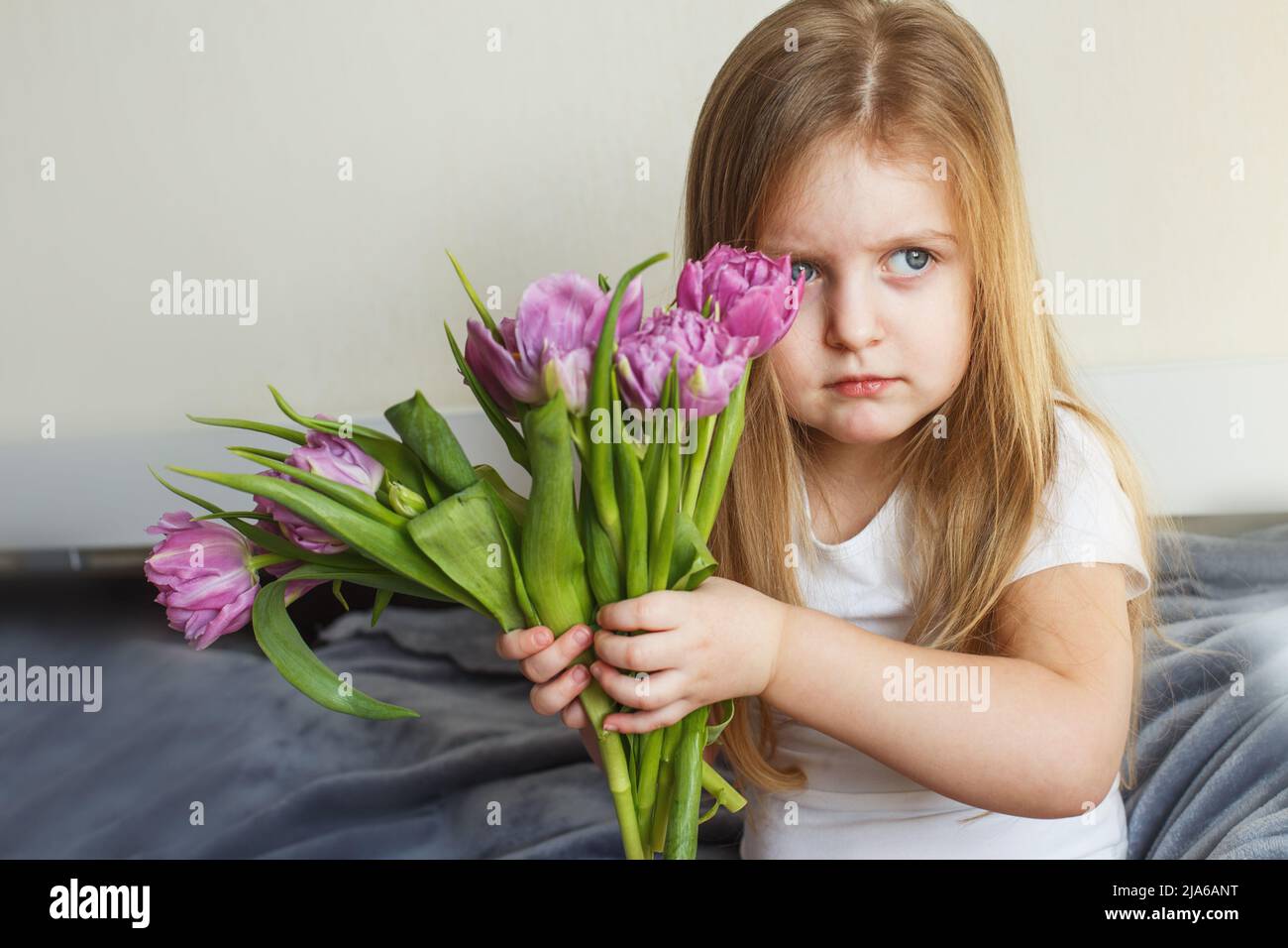 portrait of a litlle girl with bouquet of flowers tulips in her hands Stock Photo
