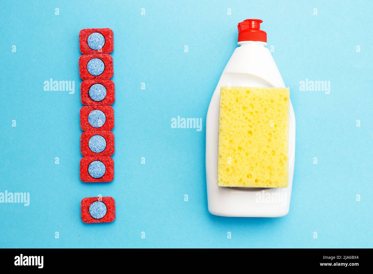 capsules for dishwashers, dishwashing detergents liquid and sponges on a blue background. dishwasher vs hand wash concept. which is better. flat lay. Stock Photo