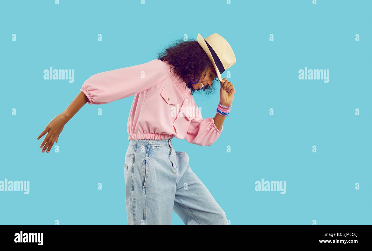 Cheerful African American child in summer clothes dancing isolated on blue background Stock Photo