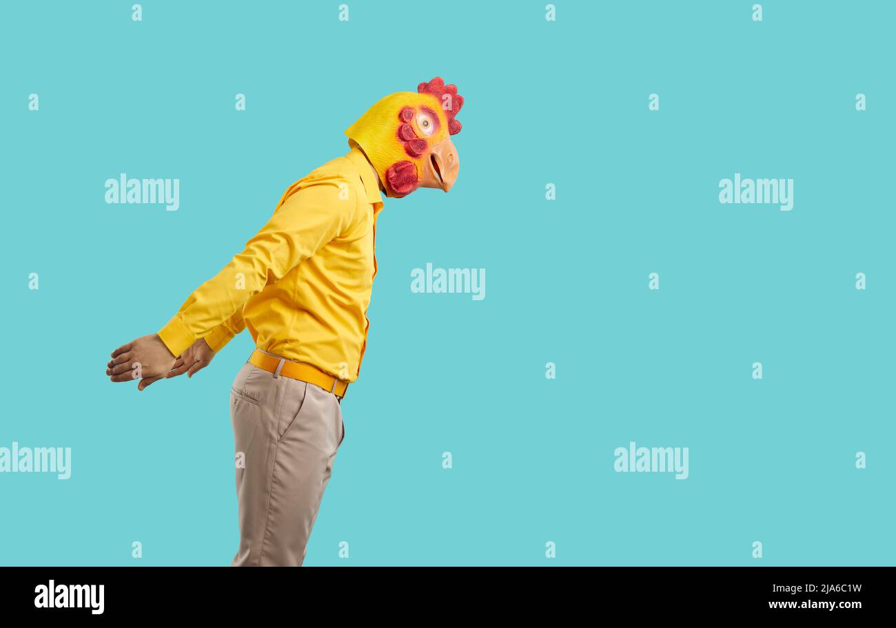Side view of man wearing clothes and funny chicken mask getting ready to jump in water Stock Photo