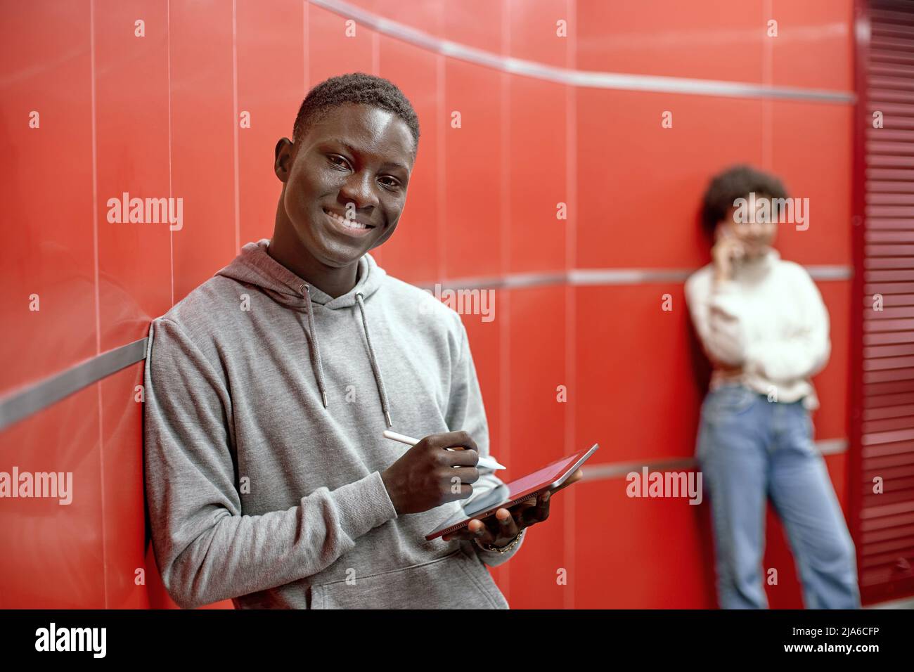 smiling guy with a digital tablet looking at the camera . Stock Photo