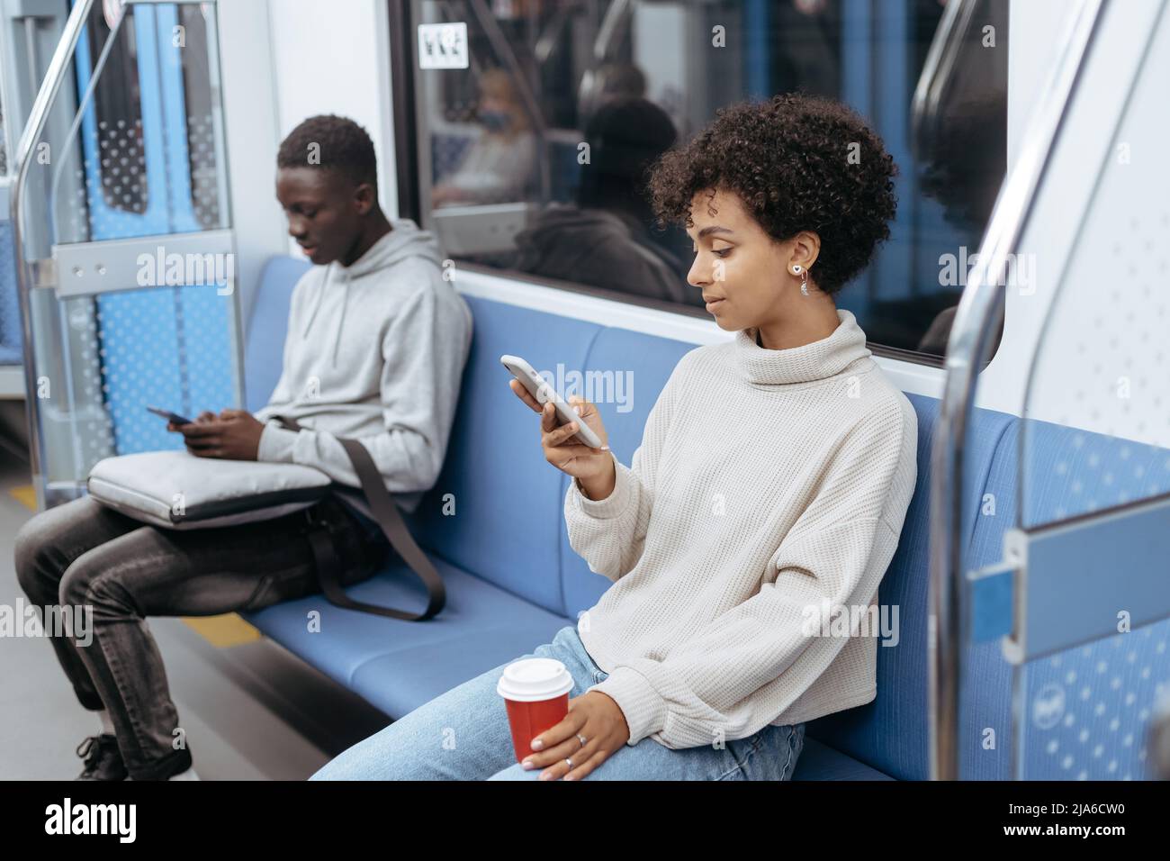 subway passengers using their smartphones while sitting in the c Stock Photo