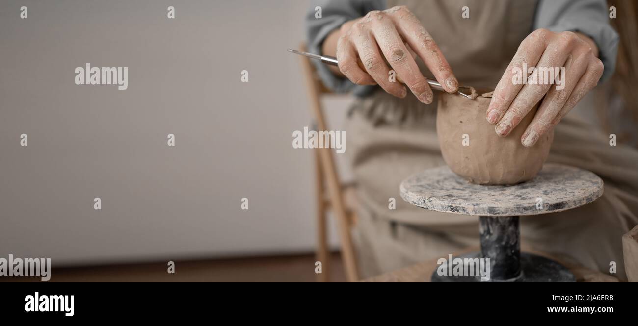 Close-up of female hands working with clay. the potter makes dishes and other handicrafts. Ceramics. Hobby and leisure concept, Stock Photo