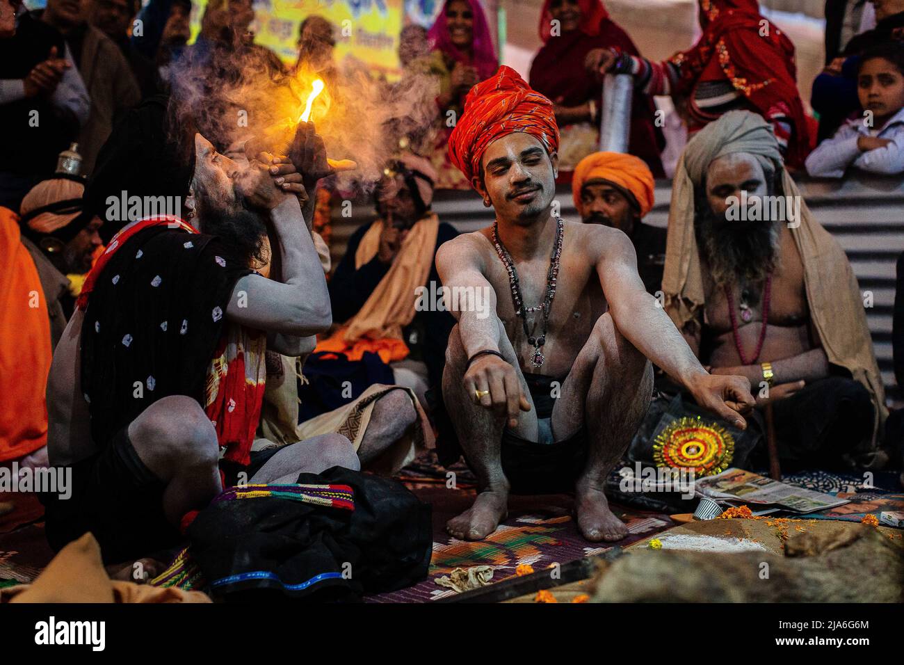 A sadhu smokes a chillum containing cannabinoids during a gathering of holy men. Every twelve years, millions of Hindu devotees begin a massive pilgrimage to the most sacred of Indian festivals: the Kumbha Mela, which takes place in Prayagraj, a place considered particularly auspicious because it is at the confluence of the Ganges, Yamuna and the mythical Saraswati. It is estimated that in 2019, 120 million people attended the sacred enclosure over the course of a month and a half. These numbers, equivalent to the total population of Japan, and 40 times the number of pilgrims who visit Mecca i Stock Photo