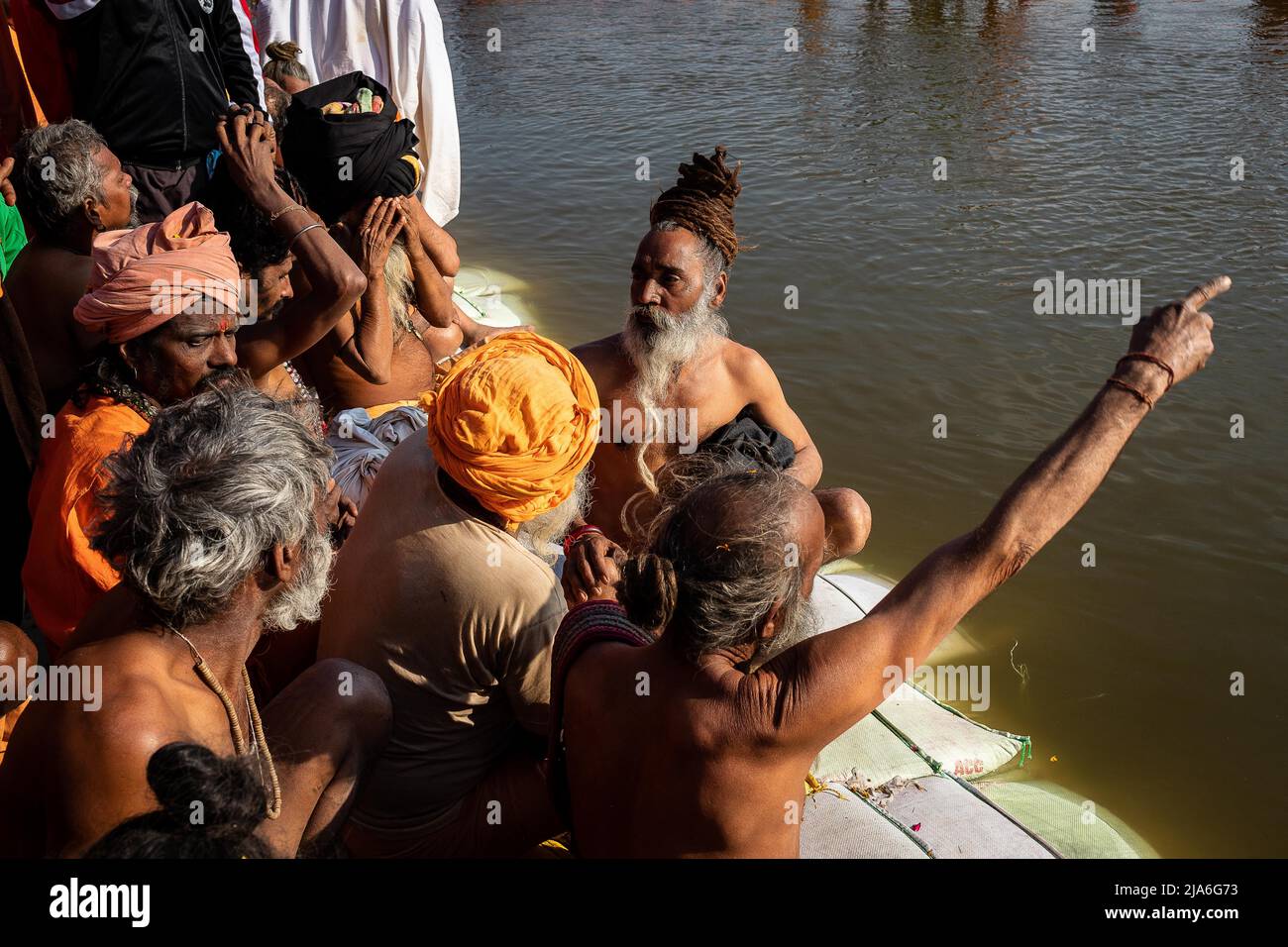 Naga sadhus wait for their moment to bathe in the holy waters of the Ganges river during the Kumbh Mela festival. Every twelve years, millions of Hindu devotees begin a massive pilgrimage to the most sacred of Indian festivals: the Kumbha Mela, which takes place in Prayagraj, a place considered particularly auspicious because it is at the confluence of the Ganges, Yamuna and the mythical Saraswati. It is estimated that in 2019, 120 million people attended the sacred enclosure over the course of a month and a half. These numbers, equivalent to the total population of Japan, and 40 times the num Stock Photo