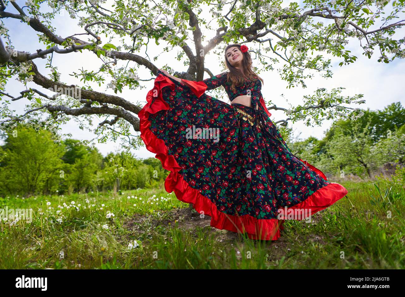 Young woman in traditional gypsy dress, performing a dance in an apple  orchard Stock Photo - Alamy