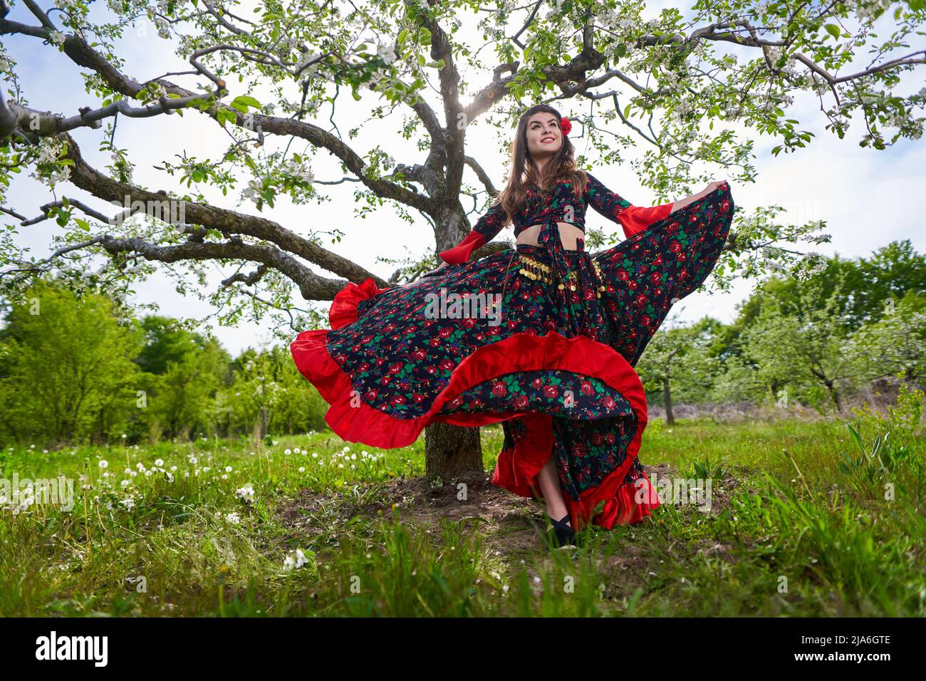Young woman in traditional gypsy dress, performing a dance in an apple  orchard Stock Photo - Alamy