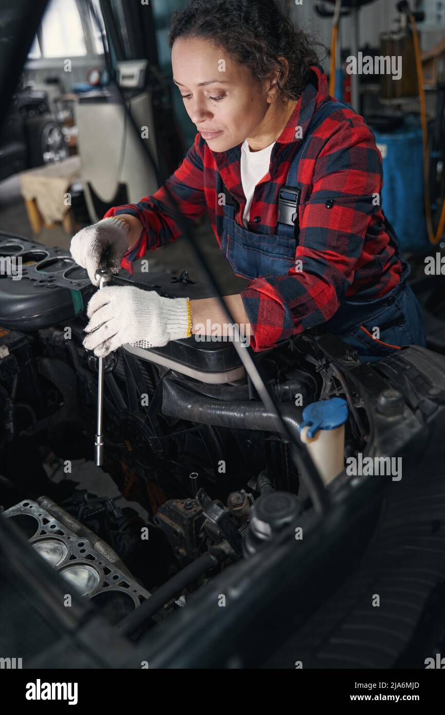 Female auto mechanic repairing car at repair service station Stock