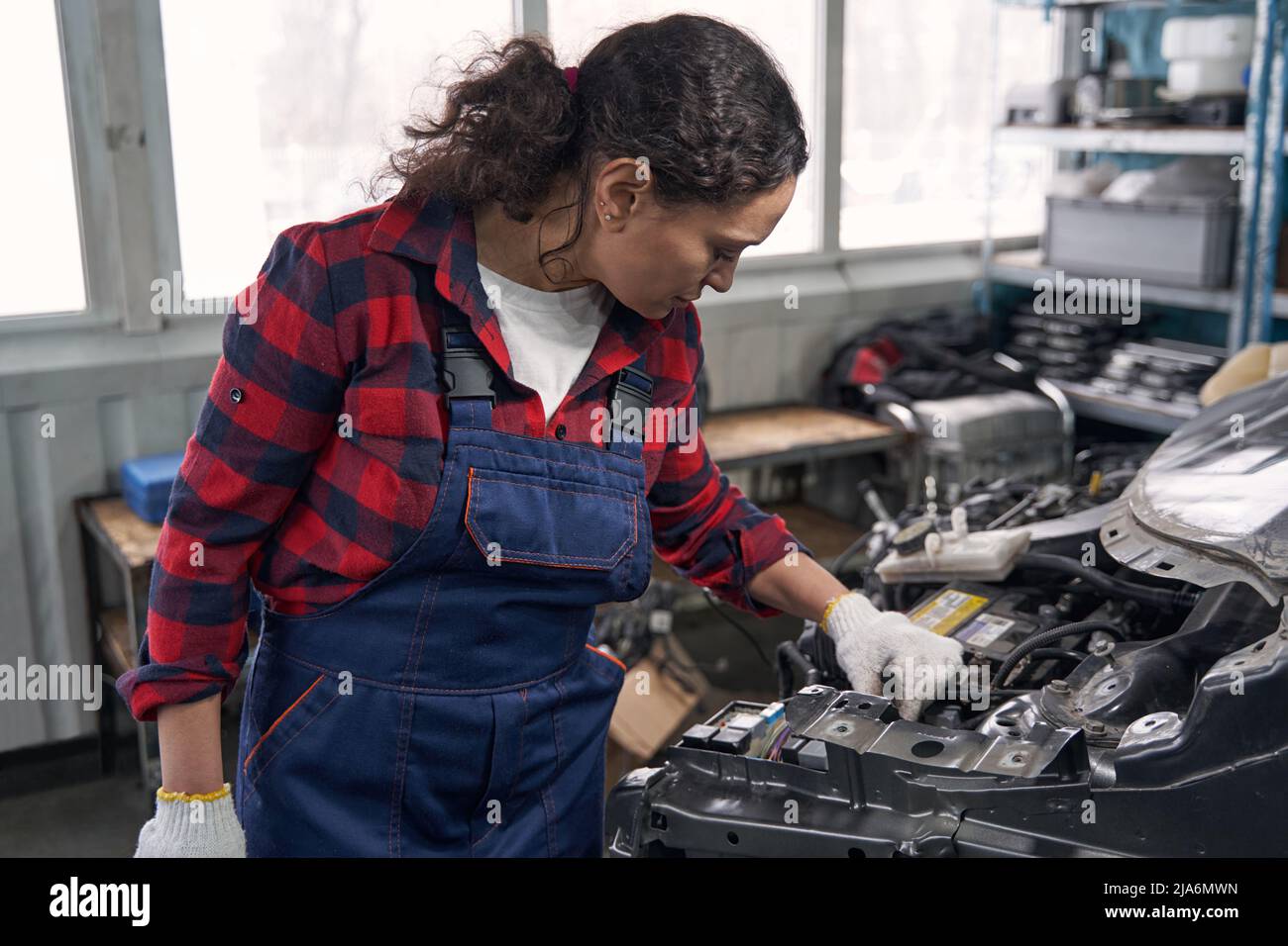 Woman auto mechanic inspecting car in auto repair shop Stock Photo - Alamy