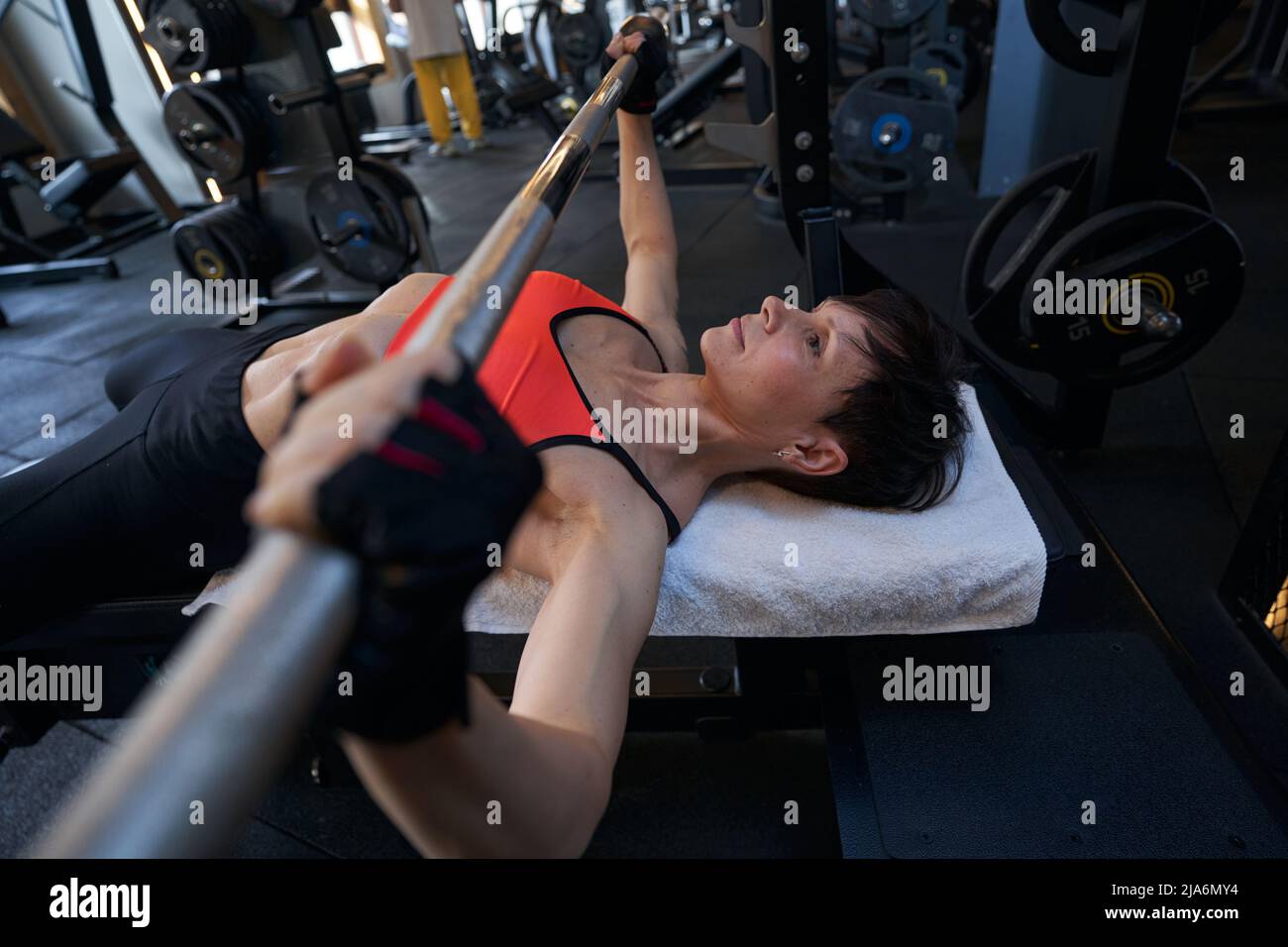 Professional female bodybuilder performing upper-body weight-training exercise Stock Photo