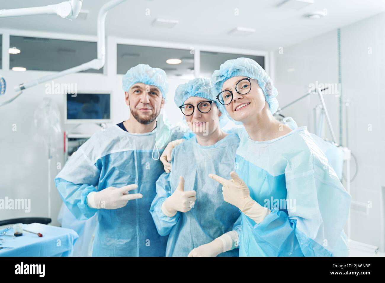 Excited surgical team posing for photo in operation room Stock Photo ...