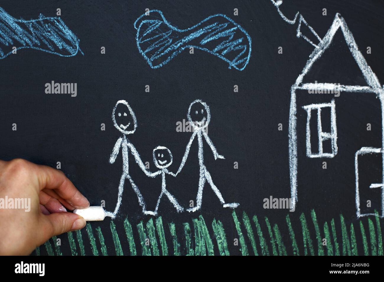 drawing happy homosexual parents with a child on a chalk board. Gay family concept Stock Photo