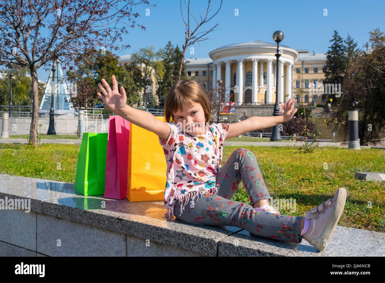 The happy child in the city with packages for purchases. Stock Photo